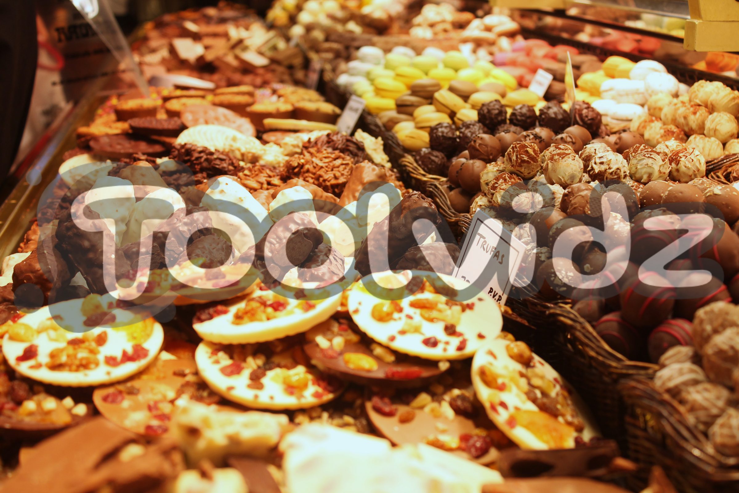 Tanti dolci al cioccolato, frutta e crema su una bancarella di un mercato spagnolo